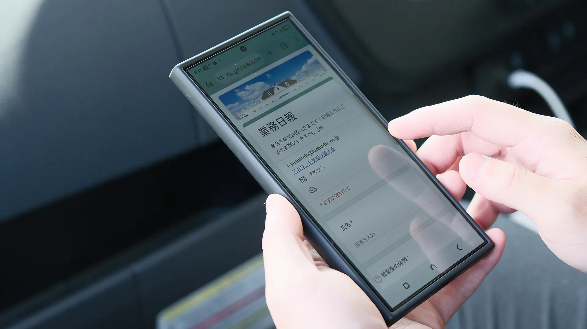 車内でスマートフォンのWeb業務日報フォームに入力する様子